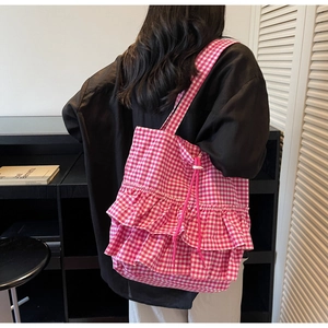 Detail of pink gingham tote bag featuring double-layered ruffles and drawstring accents