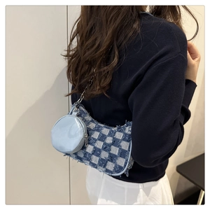 Dettaglio borsa a tracolla in denim a scacchi blu con frange e catena metallica