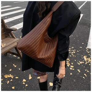 Macro view of caramel woven leather tote bag texture and autumn street style