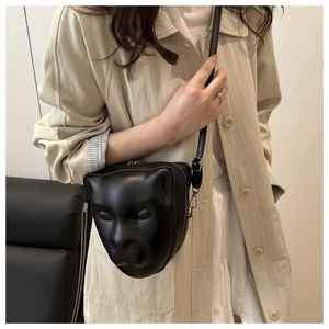 Détail du sac bandoulière tête de léopard 3D mat assorti à un trench-coat de couleur beige