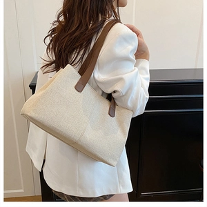 Detail of premium canvas tote featuring leather shoulder straps and reinforced stitching
