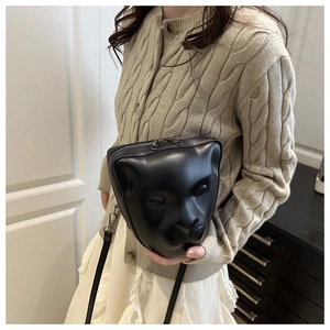Détail d'un relief 3D de chat sur un sac à bandoulière noir avec sangle réglable