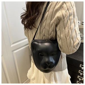 Vue détaillée du sac bandoulière 3D en forme de tête d'animal porté avec un pull beige