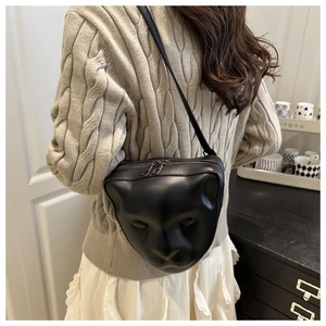 Détail du visage de chat en relief 3D sur le sac à bandoulière en cuir noir mat