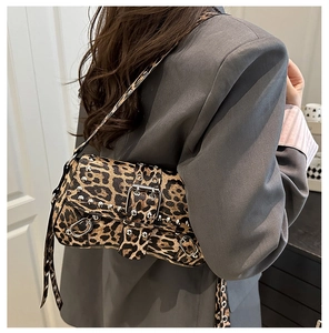 Detalle del bolso de hombro con estampado de leopardo, tachuelas de plata y hebilla