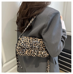 Detail of leopard print shoulder bag with silver studs worn with a grey blazer
