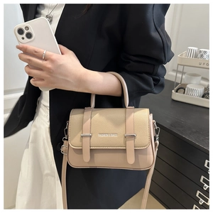 Close-up of khaki patchwork box bag showing litchi leather texture and top handle