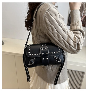 Detalle de bolso negro Y2K con tachuelas metálicas y correas de hebilla ajustables