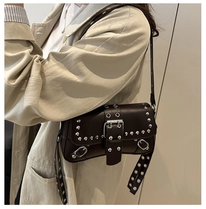 Detail of vintage dark brown faux leather bag with silver studs and metal buckle strap
