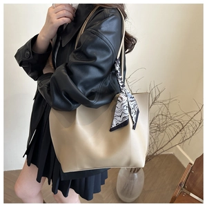 Detail of minimalist beige tote bag with a chic black and white geometric silk scarf