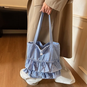 Blue and white gingham canvas tote bag with ruffled hem design and drawstring closure