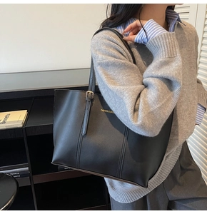 Close-up of black leather tote bag featuring gold Fashion & Bags print on shoulder