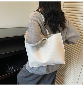 Minimalist white leather tote bag with Fashion & Bags text shown on model shoulder