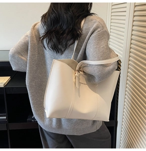 Dettaglio della borsa tote bianca minimalista con cuciture raffinate e profilo sulla spalla