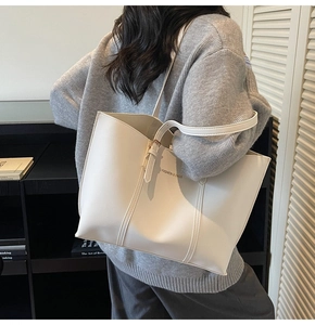 Détail du grand sac cabas en similicuir mat blanc avec bandoulière et boucles dorées