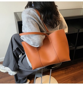 Detail of caramel faux leather tote bag with decorative stitching and large capacity