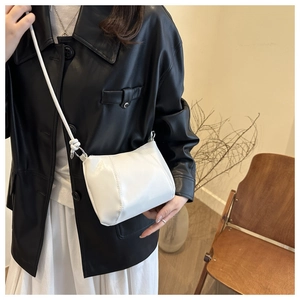 Detailed view of a white PU crossbody bag featuring silver buckles and topstitching details