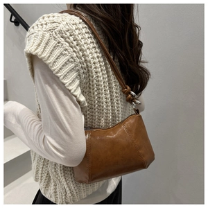 Detailed side view of vintage brown crossbody bag with oily wax leather texture and strap
