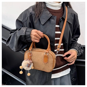 Sac bowling en daim marron avec charm mouton porté dans une tenue d'automne chic