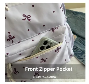 Détail de la poche zippée avant avec imprimé nœud, montrant la capacité pour téléphone