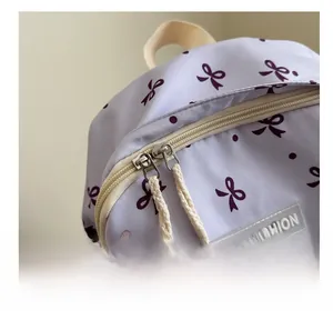 Détail de la fermeture éclair métallique et imprimé nœud sur le sac à dos violet