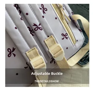 Détail de la boucle réglable sur un sac à dos en toile violette à motif de nœuds