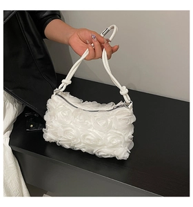 Detail of 3D fabric rose texture and metal zipper on white fashion shoulder bag