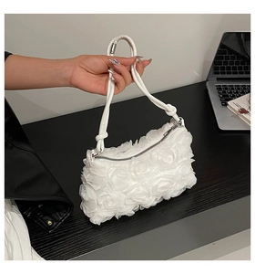 Detail showing the 3D rose flower pleats and zip closure of this white floral handbag