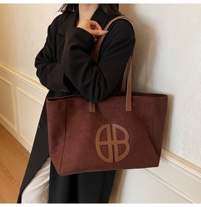 Detail of vintage large burgundy tote bag with circular cutout pattern and leather strap