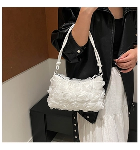 Detailed close-up of 3D fabric rose flower decor on a white elegant shoulder bag