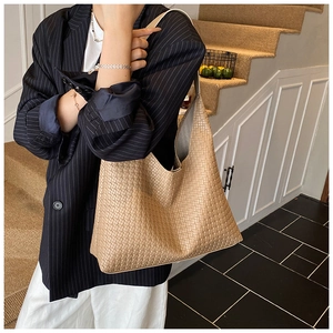 Close-up of fine woven leather texture and integrated strap on a khaki hobo tote bag