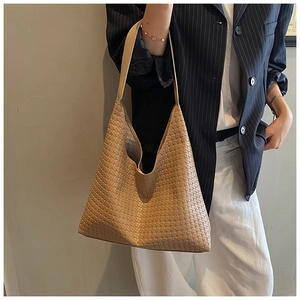 Close-up of woven leather texture on a khaki oversized hobo tote bag for women