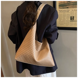 Detail of light camel woven leather shoulder bag with a honeycomb pattern texture