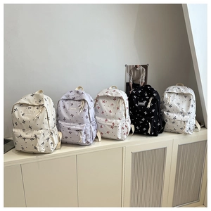 Série de sacs à dos en toile avec motifs de nœuds en plusieurs couleurs sur étagère