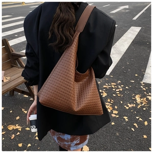 Vista dettagliata della borsa hobo in pelle intrecciata marrone con ampia tracolla