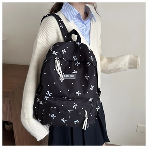 Détail d'un sac à dos d'école avec imprimés de nœuds et étiquette tissée tendance