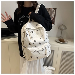Détails du motif à nœuds et de l'étiquette de mode sur le sac à dos en toile blanche