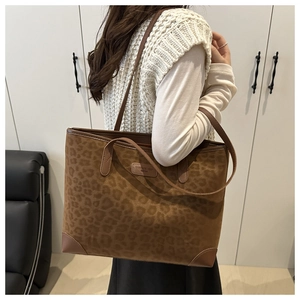 Makro-Detail der Totebag aus Wildleder mit Leopardenmuster, Markenlogo und Eckenverstärkung