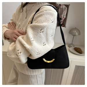 Detailed view of a black hobo bag featuring a gold crescent-shaped metal buckle closure