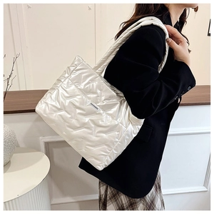 Detalle del bolso tote acolchado blanco perla con etiqueta de moda sobre el hombro