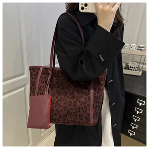Detail of leopard print tote bag with plush fabric texture and red zipper coin pouch