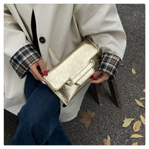 Detailaufnahme einer goldenen Abend-Clutch mit Falten-Design und Umschlag-Klappe