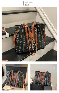 Detail of black tote bag with bear print, diamond pattern and orange shoulder strap