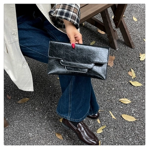 Detail der schwarzen Öl-Wachs-Lederstruktur und Umschlag-Design dieser modischen Clutch
