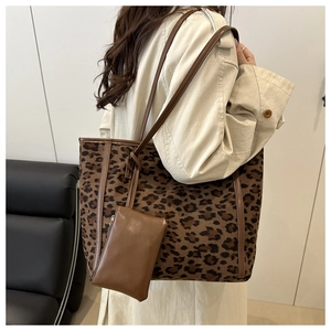 Detail of leopard print tote bag with brown leather strap and small accessory pouch