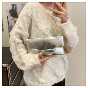 Detail der silbernen PU-Clutch mit Metallic-Struktur und Umschlagklappe für den Abend
