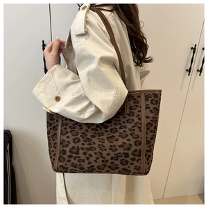 Dettaglio borsa shopper leopardata con grande capacità e rifiniture in pelle marrone