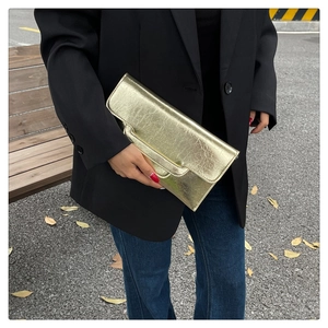 Schicke goldene rechteckige Clutch-Tasche mit strukturierter Oberfläche in Außenumgebung