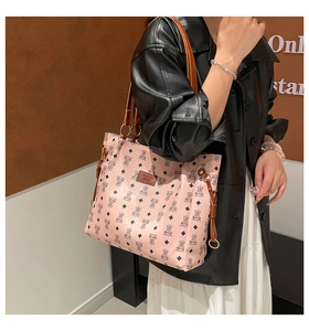 Detail of pink shoulder bag with bear print, textured leather, and brand logo
