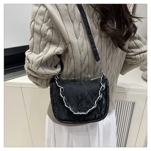 Détail du sac bandoulière plissé noir avec chaîne argentée et sangle en cuir réglable